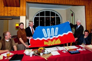 Flaggenparade im Schillsdorfer Landgasthof Kirschenholz. Bei der Übergabe des neuen Amtswappens hatte Landrat Volkram Gebel (Mitte) für jede Gemeinde eine Flagge im Gepäck. 