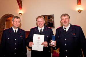 Zwei besondere Ehrungen sprach Feuerwehrleiter Hubert Ehlers (rechts) Sonnabend aus. Friedhelm Fisse (links) aus Schillsdorf wurde mit der Bandschnalle für 30 Jahre Feuerwehr geehrt. Hauke Lüth (Mitte) erhielt für 25 Jahre freiwilligen Dienst das Brandschutzehrenzeichen in Silber am Bande. 