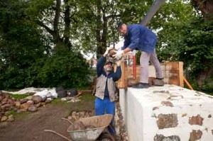 IMG_1765 Die neue Forschungswand in Bornhöved nimmt Gestalt an. Rund 20 Tonnen wiegt das bisherige Teilstück. Etwa 30 Tonnen werden es bis zur Fertigstellung. Bis dahin müssen Karl-Heinz Philipp und Jürgen Kreutzfeldt (von links) von der Lübecker Kirchenbauhütte noch manchen Stein bewegen.