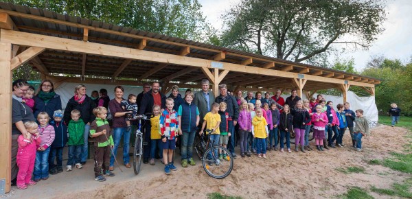 Viel Platz für Fahrräder, Pausenunterstand und Raum für Veranstaltungen im Freien, freuten sich Rendswührens Eltern, Kinder und die Bauhelfer um Bürgermeister Dr. Thomas Bahr (Mitte links) und Bauleiter Manfred Urbasch (Mitte rechts).     