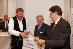 Zimmerer Jan-Henrik Jahns aus Großharriefeld freute sich in Kiel über den 4. Platz beim VR-Förderpreis 2014. Firmenkundenleiter Holger Bajorat von der Volksbank Neumünster (Mitte) und Wirtschaftsminister Reinhard Meyer gratulierten.   