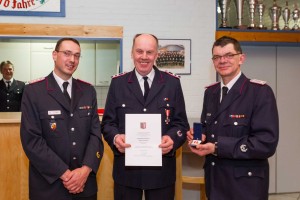 In Großharrie wurde der Hauptfeuerwehrmann Holger Heeschen (Mitte) für 40 Jahre aktiven Dienst mit dem Brandschutz-Ehrenzeichen in Gold am Bande geehrt. Amtswehrführer Holger Jebe (links) und Gemeindewehrführer Jan-Christof Böhlk (rechts) gratulierten. 